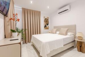 a white bedroom with a bed and a television at Azure Bliss in Costa de Adeje +22 photos