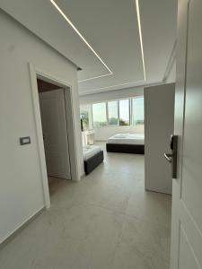 une chambre blanche avec un lit et une fenêtre dans l'établissement Dashaj Rooms 305, à Ksamil