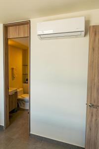 グアダラハラにあるHospedaje cerca Auditorio Telmex con A/Cの白い壁のバスルーム(トイレ付) +93枚の写真