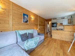 ein Wohnzimmer mit einer blauen Couch und einer Küche in der Unterkunft Appartement spacieux au pied des pistes de Val-d'Isère avec balcon - Animaux acceptés, Wifi - FR-1-694-433 in Val dʼIsère