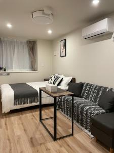 a living room with a bed and a couch at T-HOTEL Iriya - Vacation STAY 94122v in Tokyo
