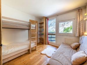 ein Schlafzimmer mit einem Etagenbett und einem Sofa in der Unterkunft Appartement spacieux au pied des pistes de Val-d'Isère avec balcon - Animaux acceptés, Wifi - FR-1-694-433 in Val dʼIsère