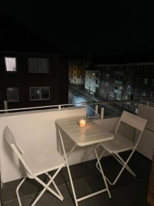 a table and chairs on a balcony with a candle at Monteurswohnung Wilhelmshafen in Wilhelmshaven