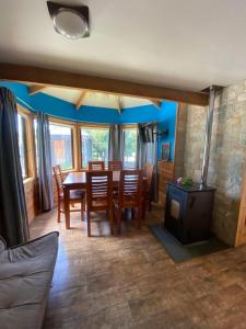 a dining room with a table and chairs and a fireplace at Cabañas Estacion del Lago in Puerto Varas
