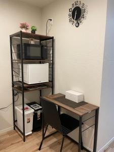 a desk with a computer and a microwave and a table at T-HOTEL Iriya - Vacation STAY 94109v in Tokyo