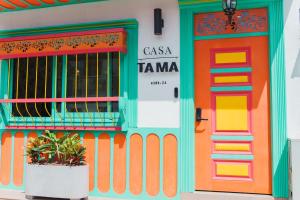 a colorful building with a colorful door and a plant at Hotel Casa Tama in Salento
