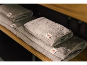 a group of towels sitting on a shelf at BASE LAYER HOTEL NAGOYA NISHIKI - Vacation STAY 98099v in Nagoya