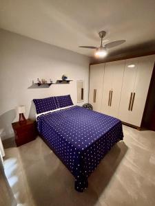 a blue bed in a bedroom with a ceiling at Casa térrea em condomínio à 500m da praia do Peró in Cabo Frio