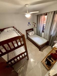 a room with two bunk beds and a window at Casa térrea em condomínio à 500m da praia do Peró in Cabo Frio