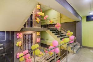 a staircase with pink and yellow balloons in a building at Capital O Divira Inn in Dhanbād