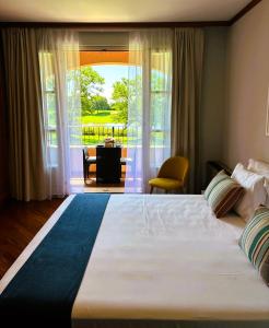 ein großes Bett in einem Zimmer mit einem großen Fenster in der Unterkunft Jasmine Golf & Malpensa, studio in Robinie club in Solbiate Olona