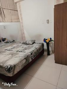 a bedroom with a bed and a vase of flowers at HOSPEDAJE MARISCAL CASTILLA in Tumbes