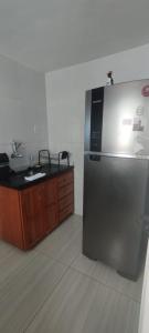 a kitchen with a stainless steel refrigerator and a counter at Casa Azul em Santa Tereza in Belo Horizonte