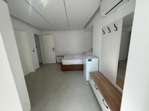 une chambre blanche avec un lit et une table dans l'établissement Dashaj Rooms 301, à Ksamil