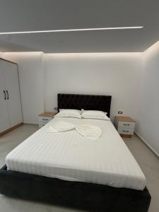 une chambre avec un grand lit avec des draps blancs dans l'établissement Dashaj Rooms 301, à Ksamil