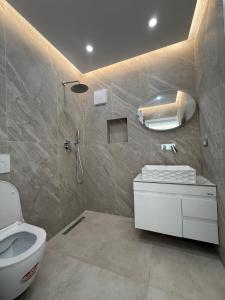 une salle de bain avec des toilettes blanches et une douche dans l'établissement Dashaj Rooms 301, à Ksamil