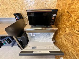 eine Mikrowelle auf einem Regal in der Unterkunft Rasta Camp Hakushu - Vacation STAY 03221v in Shirasu