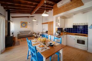 a kitchen and living room with a table and chairs at Casas da Tia Alice - Casas de campo encantadoras em Mafra in Mafra
