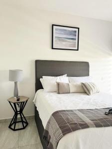 a bedroom with a bed and a table with a lamp at Marina Cerritos - Blanco Celeste - 5 Albercas in Mazatlán +20 photos