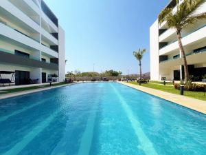 a swimming pool in front of a building at Marina Cerritos - Blanco Celeste - 5 Albercas in Mazatlán