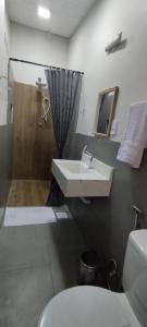 a bathroom with a sink and a shower and a toilet at Suíte Amarela da Casa Azul in Belo Horizonte
