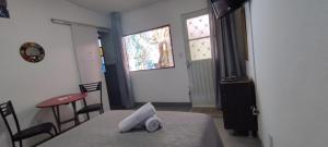 a bedroom with a bed and a table and a window at Suíte Amarela da Casa Azul in Belo Horizonte +1 photo