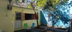 a house with two chairs and trees in front of it at Suíte Amarela da Casa Azul in Belo Horizonte