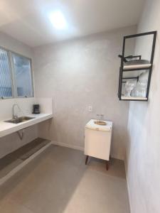 a white bathroom with a sink and a mirror at Apartamento á 1200m da Praia de Itapua in Vila Velha +55 photos