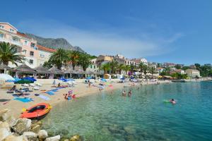 a beach with a bunch of people in the water at Villa Norah in Podgora