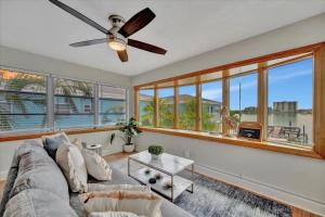 een woonkamer met een bank en een plafondventilator bij Watch the dolphins Waterview 2-bed Heated pool in Clearwater Beach