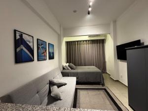 a room with two beds and a couch and a television at Pegas apartments 3 in Iguaba Grande