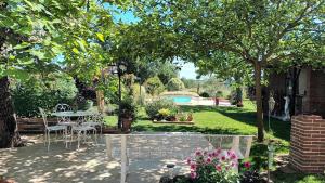 a patio with tables and chairs in a garden at Gîte d'en Pouillac in Saint-Thomas