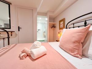 a bedroom with pink and white towels on a bed at Doux Pavillon - L'évasion - Jacuzzi & Sauna in Tassin-la-Demi-Lune