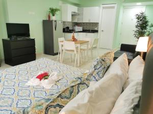 プンタ・カナにあるGreat condo with poolのリビングルーム(ベッド1台付)、キッチンが備わります。