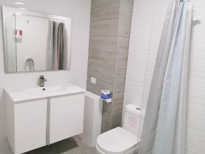 プンタ・カナにあるGreat condo with poolのトイレ、洗面台、鏡を備えたバスルーム