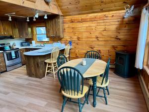a kitchen with a table and chairs in a cabin at Outta Range Outta Range, A Cozy Log Home Retreat in Rangeley