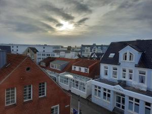 a group of buildings in a city with the sunset at Ferienwohnung Möwennest by Deju in Norderney