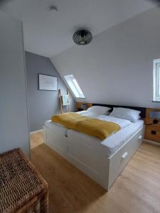 a bedroom with a bed with a yellow blanket on it at Ferienwohnung Möwennest by Deju in Norderney