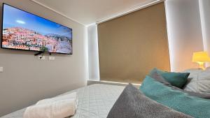 ein Schlafzimmer mit einem Bett und einem Fernseher an der Wand in der Unterkunft Movistar Arena, Parq OHiggins Estacionamiento Gratis in Santiago