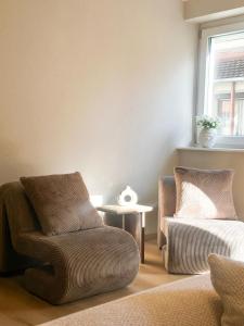a living room with two chairs and a table at Stilvolles Apartment im Herzen von Bad Mergentheim in Bad Mergentheim