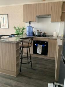 a kitchen with a counter and a table with a stool at Edificio Patricio Linch in Iquique