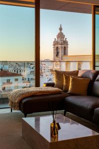 un soggiorno con divano e vista su un edificio di The View at the Downtown 5 a Faro
