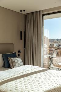 una camera da letto con un letto e una grande finestra di The View at the Downtown 5 a Faro