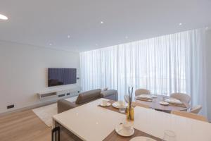 un soggiorno bianco con tavolo e TV di The View at the Downtown 5 a Faro