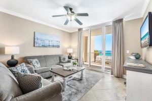 ein Wohnzimmer mit einer Couch und einem Deckenventilator in der Unterkunft Azure 305 - Beachfront Luxury Retreat in Fort Walton Beach