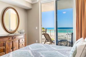 Schlafzimmer mit einem Bett und einem Spiegel sowie einem Balkon in der Unterkunft Azure 305 - Beachfront Luxury Retreat in Fort Walton Beach + 45 Fotos