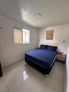 a bedroom with a blue bed and a window at Apartamento COP 30 Belém do Pará in Ananindeua