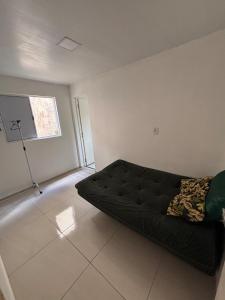 a living room with a black couch and a window at Apartamento COP 30 Belém do Pará in Ananindeua +8 photos