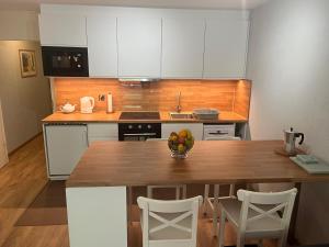 Una cocina con una mesa de madera con un bol de fruta encima. en Alpine apartment in Swiss village of Torgon, en Torgon