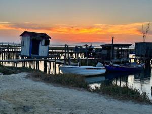 two boats are docked at a dock at sunset at Comporta Sunset Villa in Comporta +9 photos